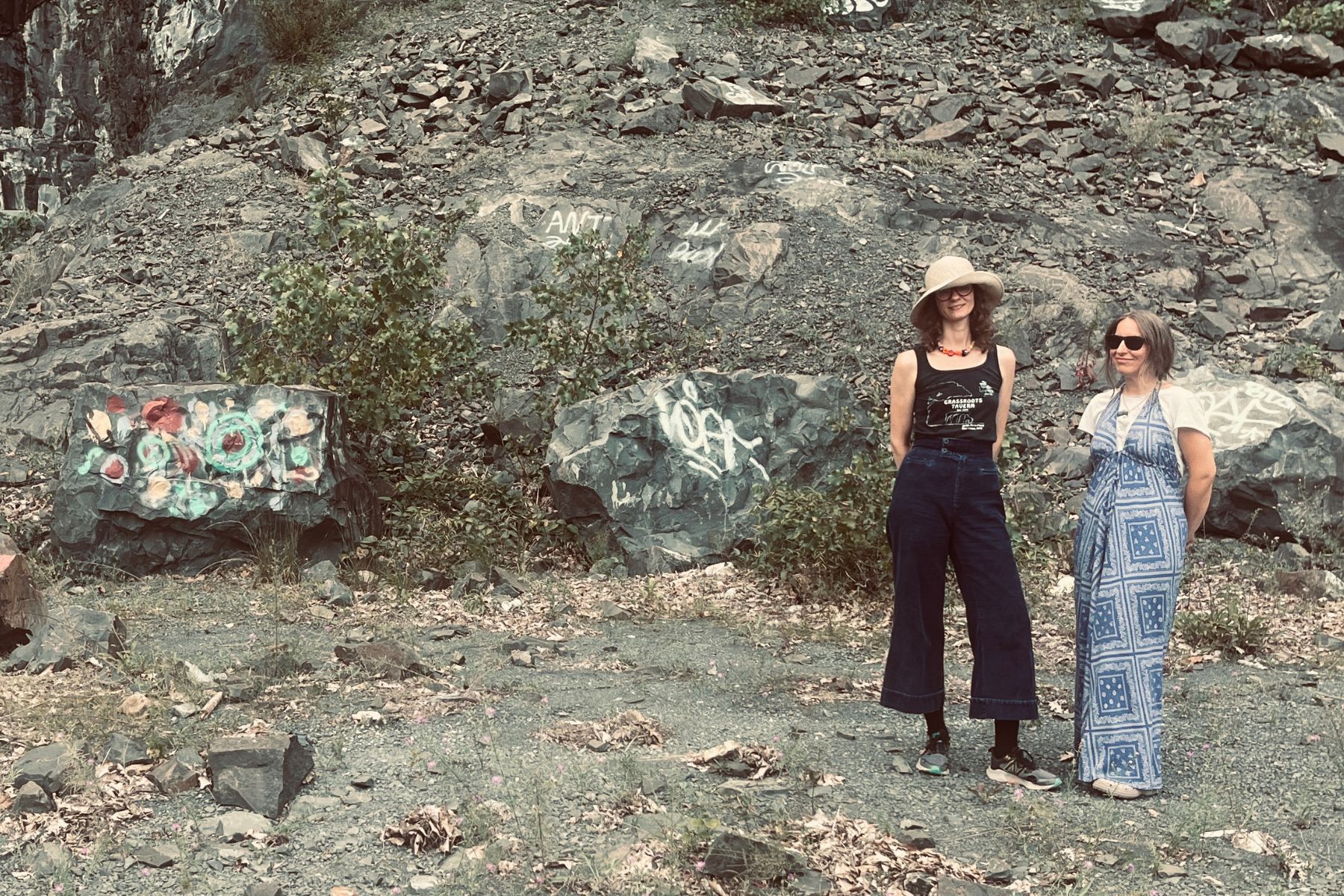 Two gals out in the woods posing in front of some nice rocks. 