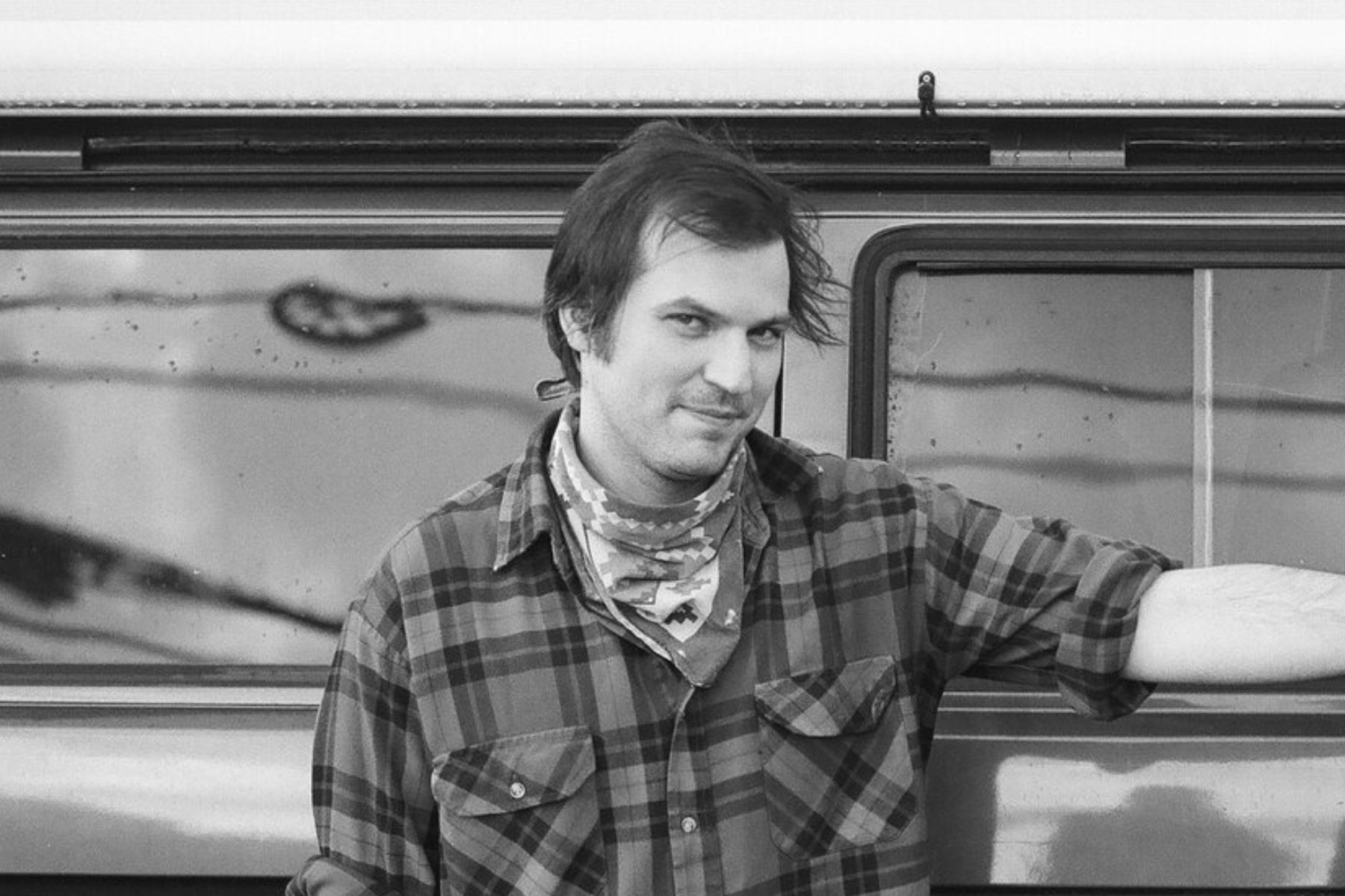 The artist looking real provocative leaning up against his truck.
