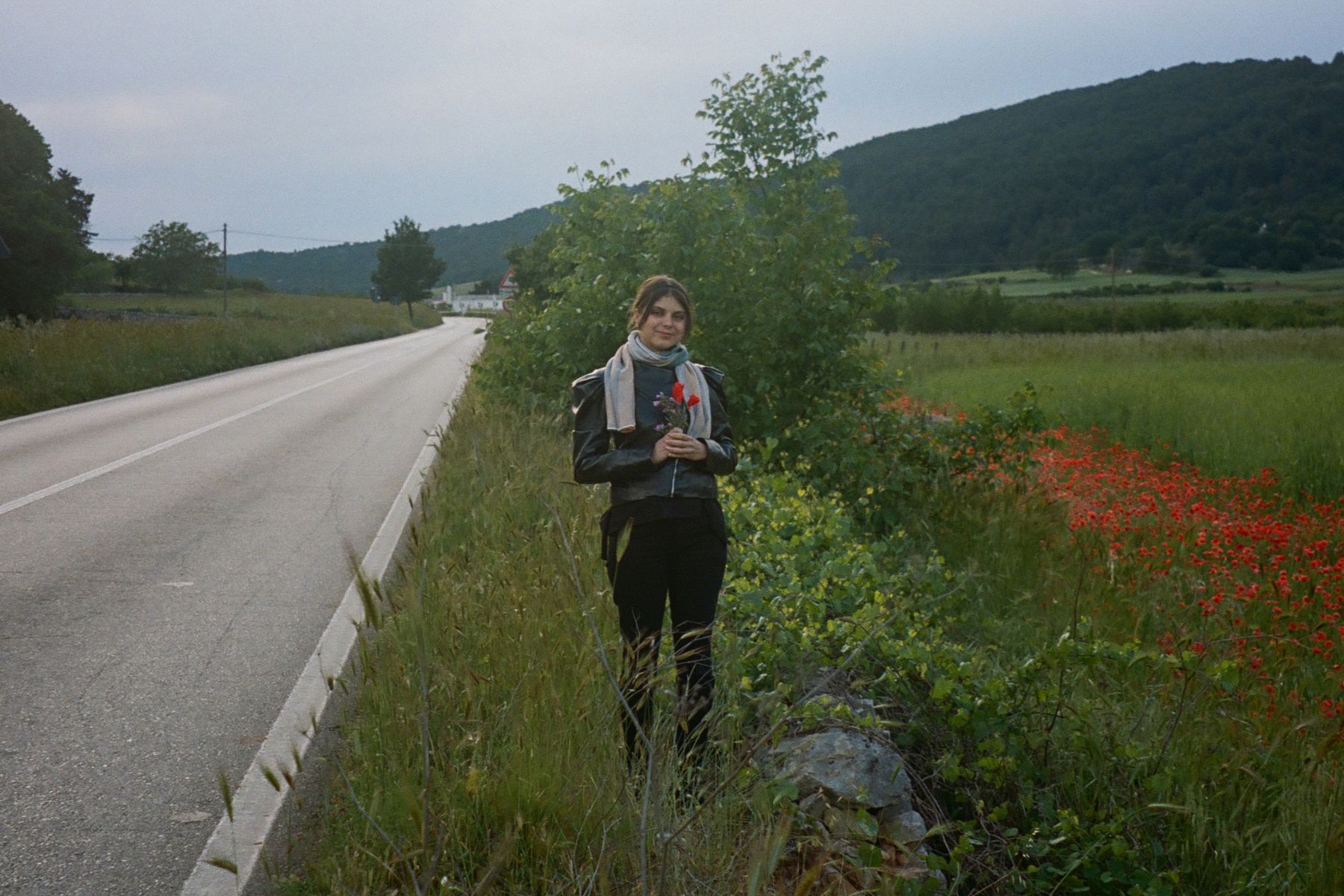 Ali on the side of the road with some freshly picked flowers.